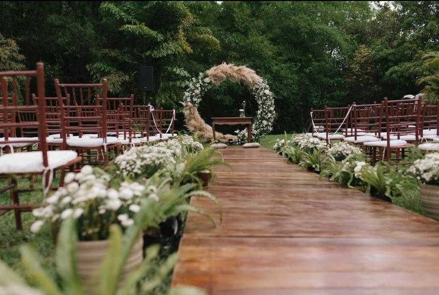 Corredor de madeira com arco floral no jardim da Villa Radnai